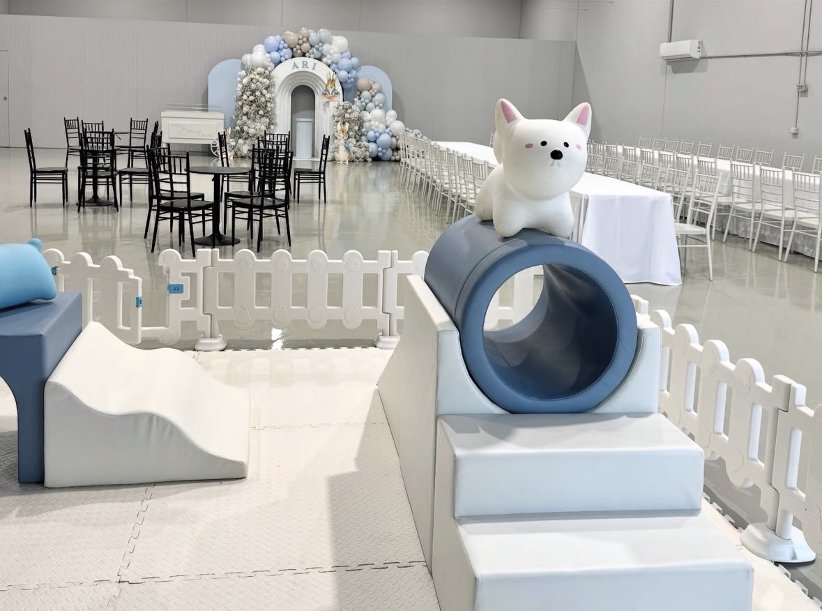 Blue and white soft play set with tunnel slide at a christening event